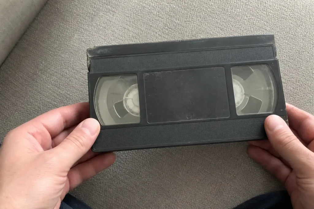 Händer håller ett slitet VHS-kassettfodral i samband med att officiell trailer släppts för vägskräckisen It Ends.